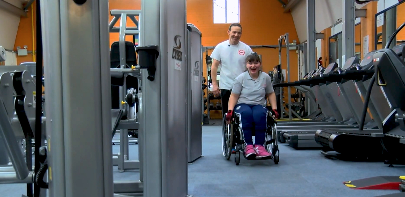 Visually Impaired student and staff member from QAC in the QAC gym